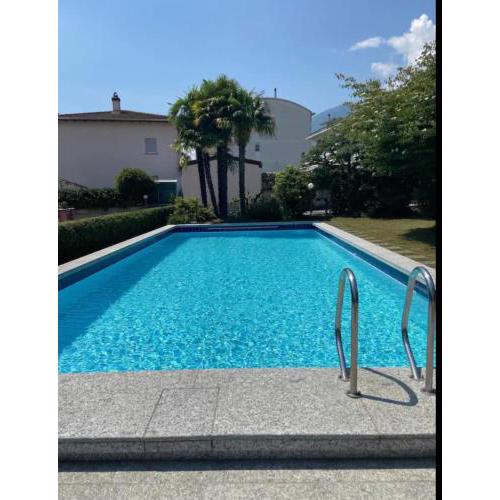 Ampia camera con balcone in casa con giardino e piscina.